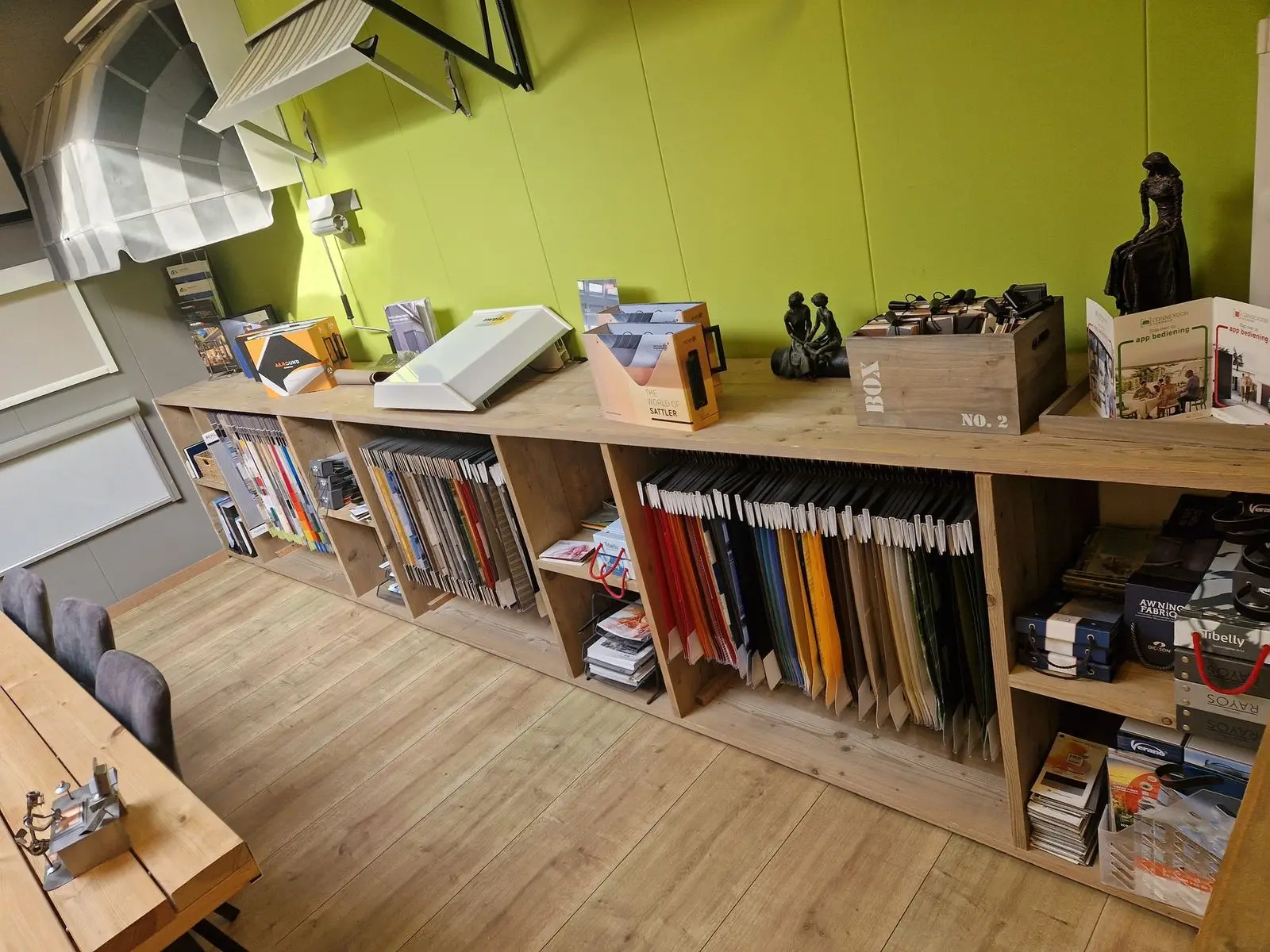Lange kast vol hangende doekstalen in de showroom van ZBN