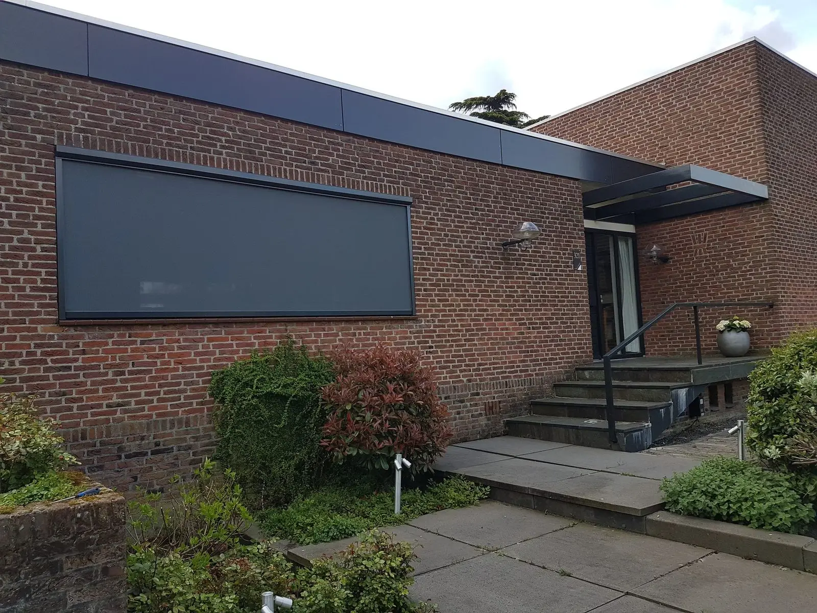 Zipscreen voor een breed raam van een laag bakstenen gebouw