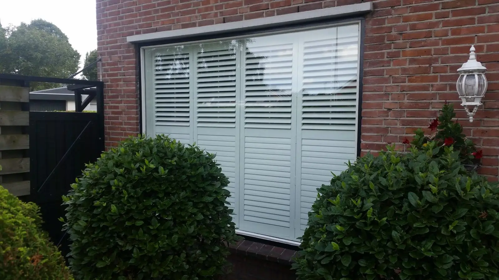 Witte shutters achter het raam, van buiten gezien