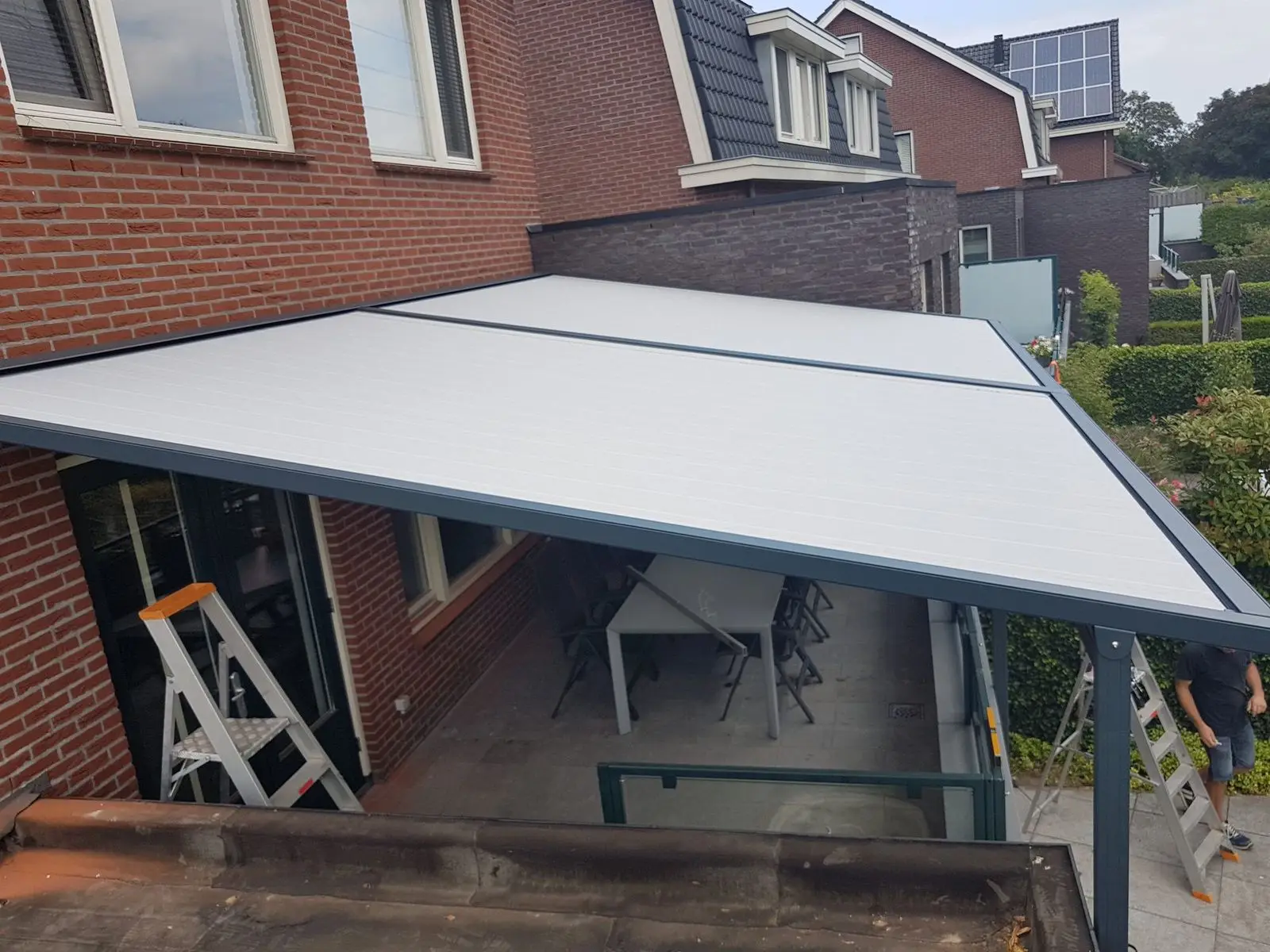 Pergolazonwering van boven gezien, met lichtgrijs doek en grijs frame
